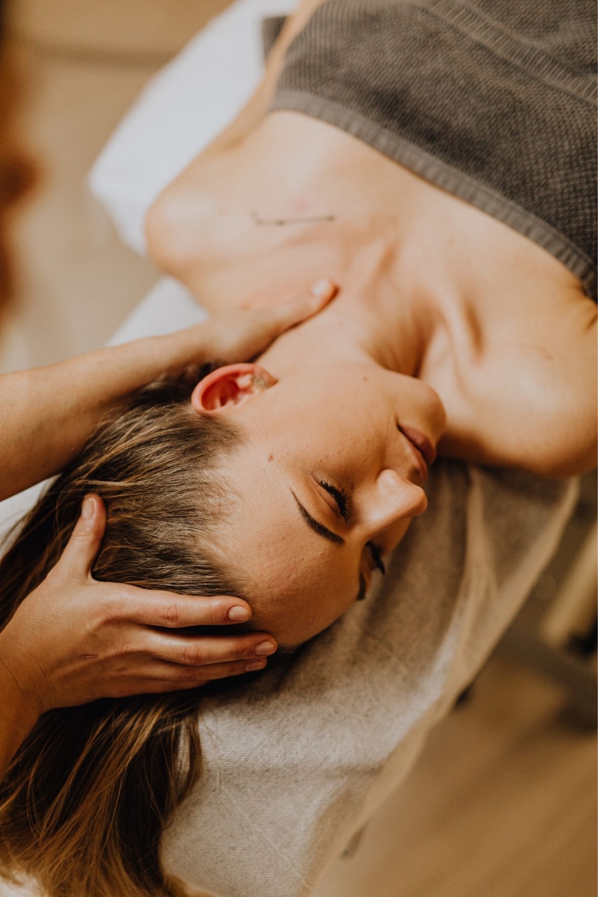 Galets décoratifs disposés près d’une table de massage dans un environnement de relaxation  à Farnham